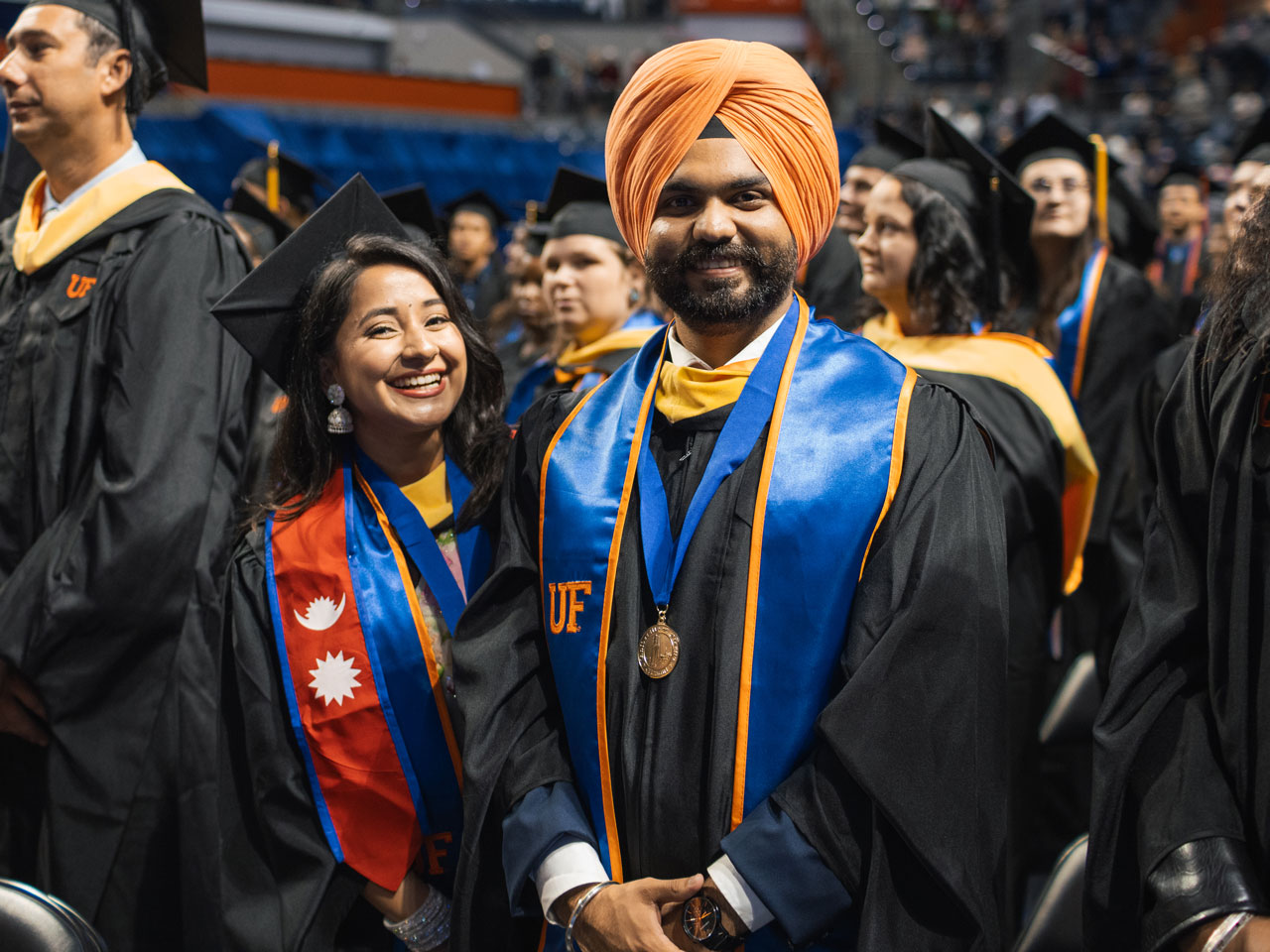 Students pose for a photo at graduation in regalia