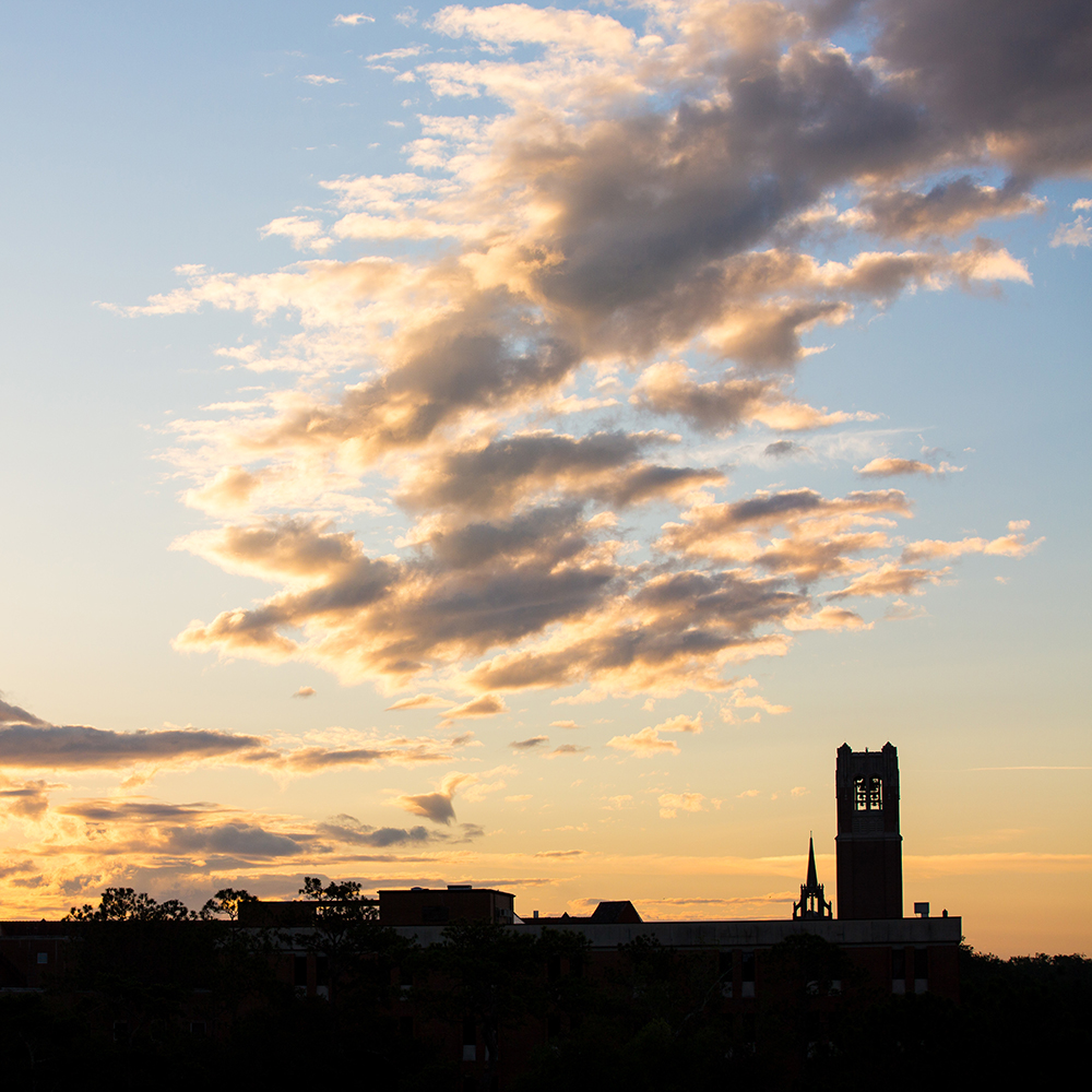 century tower and auditorium silhouetted at sunrise